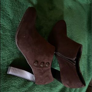 Brown booties with buttons on the side and a zipper on the inside.
